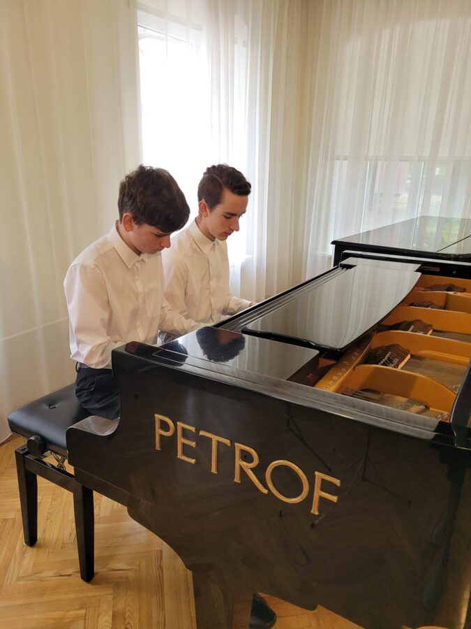 divi puikas spēlē klavieres